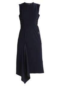 Mörkblå klänning med korta ärmar, asymmetrisk kant, slits på sidan och dekorativ snörning vid midjan. Tillverkad av ett mjukt tyg.