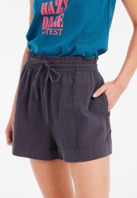 Shorts grigi scuri realizzati in tessuto leggero, con vita elastica e cordoncino, tasche laterali e vestibilità comoda.