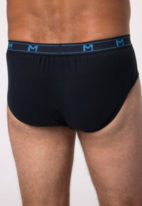 Slip in cotone nero con cintura brandizzata blu. Il tessuto è liscio con cuciture minimali, offrendo un design aderente.