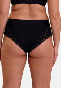 Sous-vêtements noirs avec une taille haute et des détails en dentelle le long des ouvertures de jambes. Tissu lisse avec un ajustement confortable.
