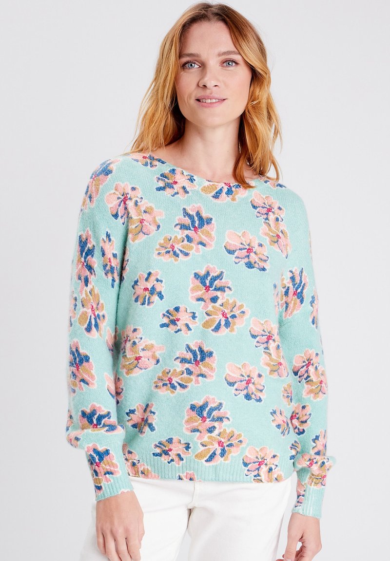Maglione azzurro chiaro con motivo floreale multicolore, polsini e orlo a coste. Realizzato in materiale morbido, presenta una vestibilità ampia e scollo rotondo.
