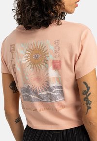Rosa kort t-skjorte laget av bomull, med et kunstnerisk grafisk motiv av en sol og bølger med tekst, korte ermer og en avslappet passform.