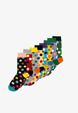 Neuf paires de chaussettes à pois colorés avec des bases et des bordures de couleurs variées, disposées en ligne décalée sur un fond blanc.