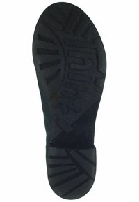 Suela de zapato de goma negra con un patrón de agarre texturizado, que presenta estrías y un logotipo de la marca en relieve. Forma ligeramente curvada, material resistente.