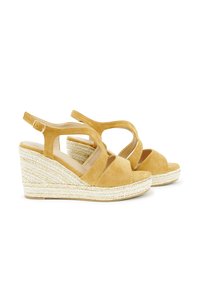 Yellow suede wedge sandals feature a strappy design with an open toe and an espadrille-style jute-covered base. Adjustable ankle strap included.