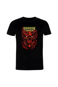 Camiseta negra de algodón con un diseño gráfico en rojo y amarillo que muestra un rostro estilizado y llamas, con la etiqueta "Stranger Things" en la parte superior.