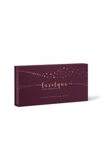 Scatola rettangolare viola con motivi di stelle dorate, etichettata con "Le Silque Pure Moments luxury silk sleep mask" sulla parte anteriore.
