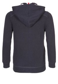 Mörkblå stickad hoodie med texturerat tyg, dragsko i huvan samt ribbade muddar och fåll. Har ett kontrasterande mönster på huvens insida.