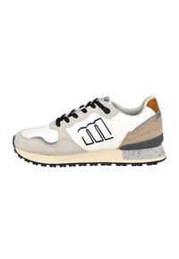 Zapatilla blanca y beige con cordones negros, un logo "m" negro en el lateral, y una suela gris moteada y una lengüeta trasera marrón.