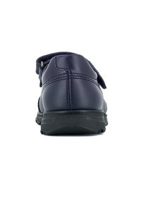 Zapato de cuero azul marino con suela de goma negra texturizada, que cuenta con una correa de velcro para el cierre y un cuello acolchado para mayor comodidad.