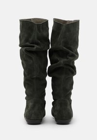 Bottes hautes jusqu'au genou en daim vert avec un design décontracté, présentant une texture lisse, des plis doux et des semelles noires.
