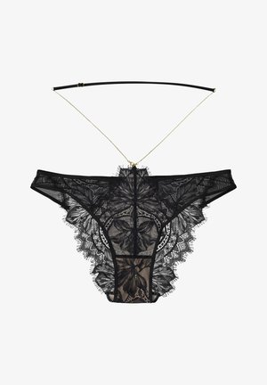 Black lace thong with floral pattern, translucent mesh, and ribbon straps. Gold chain accent at the back. Delicate fringe detail around edges.