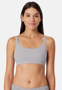 Harmaa ribbimäinen bralette, jossa on leveät hihnat ja saumaton muotoilu. Kangas näyttää pehmeältä ja joustavalta, sopii mukavuuden ja päivittäisen käytön tarpeisiin.