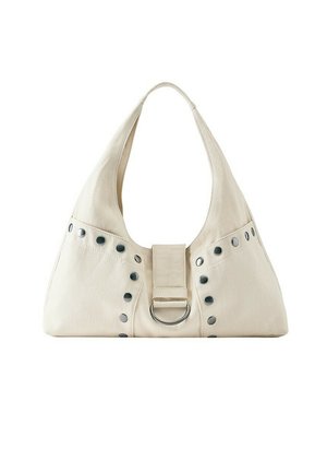 Sac à épaule en tissu beige doux avec une large bandoulière, des clous argentés sur le devant et un anneau métallique central.