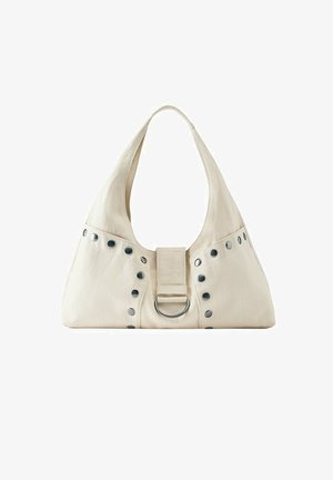 Sac à épaule en tissu beige doux avec une large bandoulière, des clous argentés sur le devant et un anneau métallique central.
