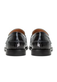 Svarta lackläders loafers med en slät yta, rund tå och låg klack, med dekorativ sömnad längs baksidan.