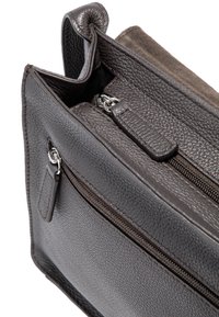 Szara torba z fakturowanej skóry z zamykanymi na zamek kieszeniami, z gładkim akcentem i małą pętelką na boku.