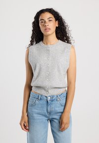 Gray sleeveless knit top with a round neckline and button closure down the front, paired with high-waisted blue jeans. Simple textured fabric.