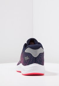 Sportovní boty s horní částí z námořnické síťoviny, růžovými akcenty a bílou podrážkou. Mají polstrovaný límec a značku "FRESH FOAM" na patě.