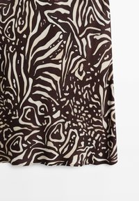 Tissu abstrait zébré marron foncé et beige avec des formes organiques irrégulières et des lignes fluides.