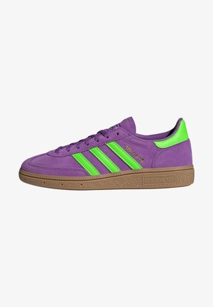 Baskets Adidas violettes avec des rayures vert néon et un onglet au talon, semelle marron texturée et marquage doré "Spezial" sur le côté.