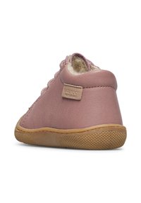 Růžová kožená dětská bota se měkkým vnitřkem, gumovou podrážkou a minimalistickým designem. Na zadní straně se nachází malá značka.