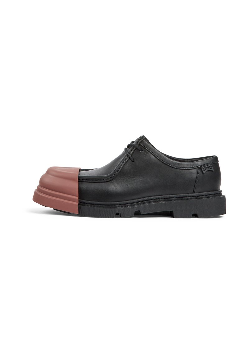 Chaussure en cuir noir avec un capuchon de orteil en caoutchouc brun rectangulaire. Présente des lacets ronds et une semelle noire texturée. Design classique avec des accents modernes.