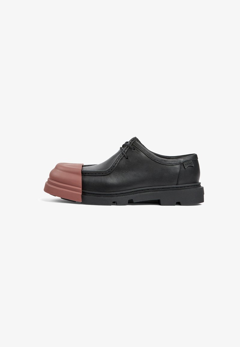 Chaussure en cuir noir avec un capuchon de orteil en caoutchouc brun rectangulaire. Présente des lacets ronds et une semelle noire texturée. Design classique avec des accents modernes.