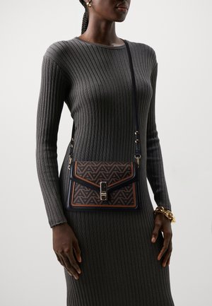 Crossbody taske med et geometrisk mønster i brun og sort, med en struktureret design, lås lukning og en aftagelig rem.