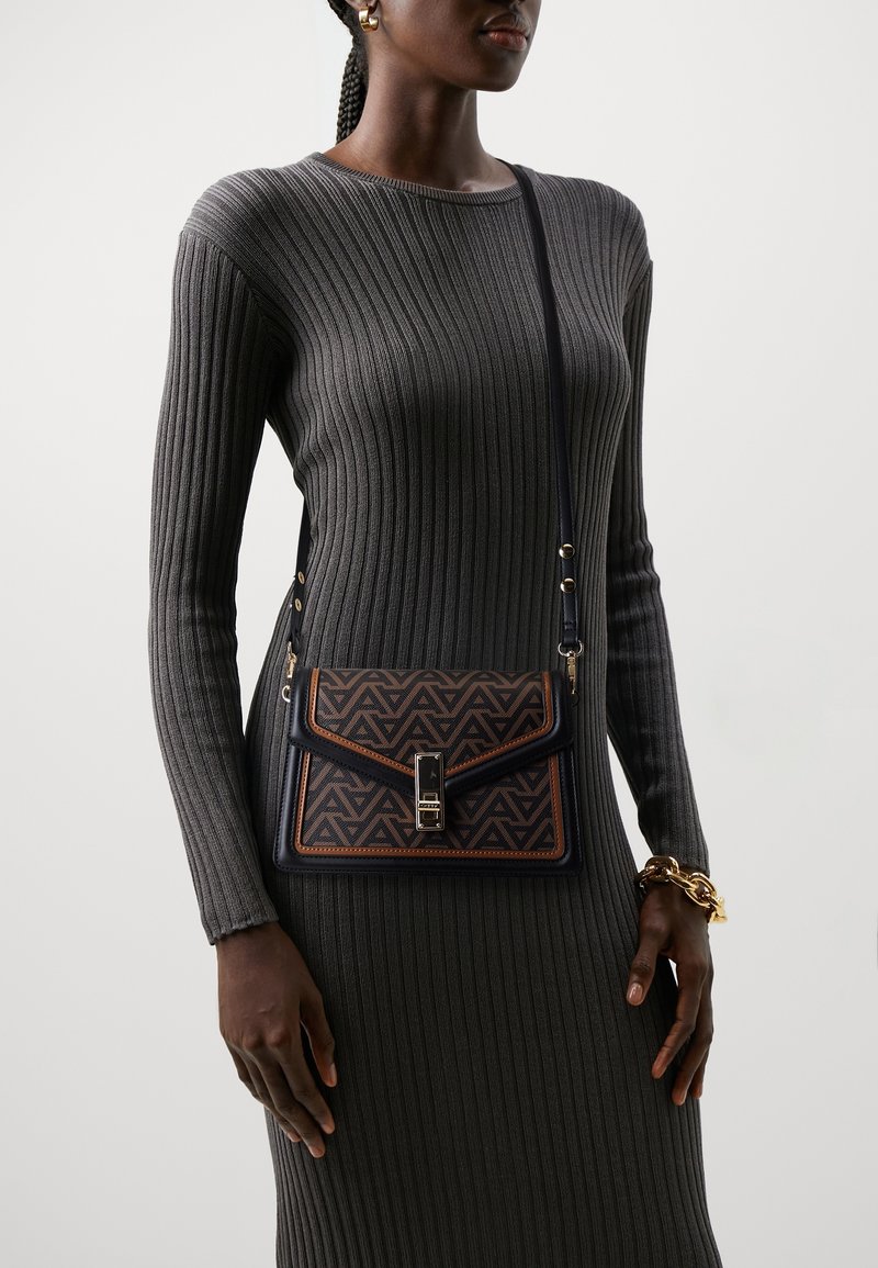 Borsa a tracolla con un motivo geometrico in marrone e nero, design strutturato, chiusura con fibbia e cinturino rimovibile.