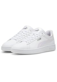 Sneaker bianche con finitura in pelle liscia, punta arrotondata, design con lacci e sottili accenti metallici sul logo e sulla striscia laterale.