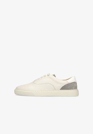 White leather sneaker with gray suede heel, round toe, lace-up closure, and flat rubber sole on a white background.