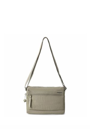 Sac bandoulière rectangulaire beige avec une poche zippée à l'avant, une sangle ajustable et un petit curseur de fermeture éclair en forme de cube.