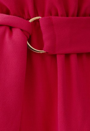 Magenta josta ar zelta metāla gredzenu, izgatavota no mīksta, strukturēta auduma. Audums savelkās ap vidu, radot pieguļošu izskatu.