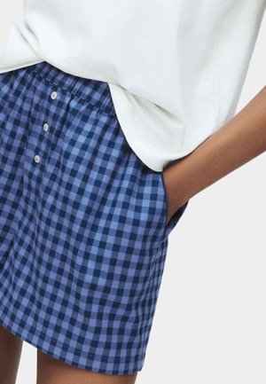 Pantaloni a scacchi blu e viola realizzati in tessuto leggero, dotati di una vita elasticizzata e dettagli con bottoni sul davanti.