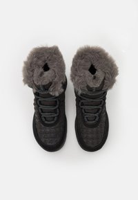 Czarne buty mid-top z teksturowaną cholewką, szarym kołnierzem z sztucznego futra i czarnymi sznurowadłami. Posiadają okrągły czubek i gumową podeszwę.