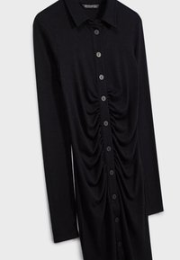 Robe noire à manches longues avec col, boutons sur le devant et détails froncés le long de la ligne de boutons au centre.