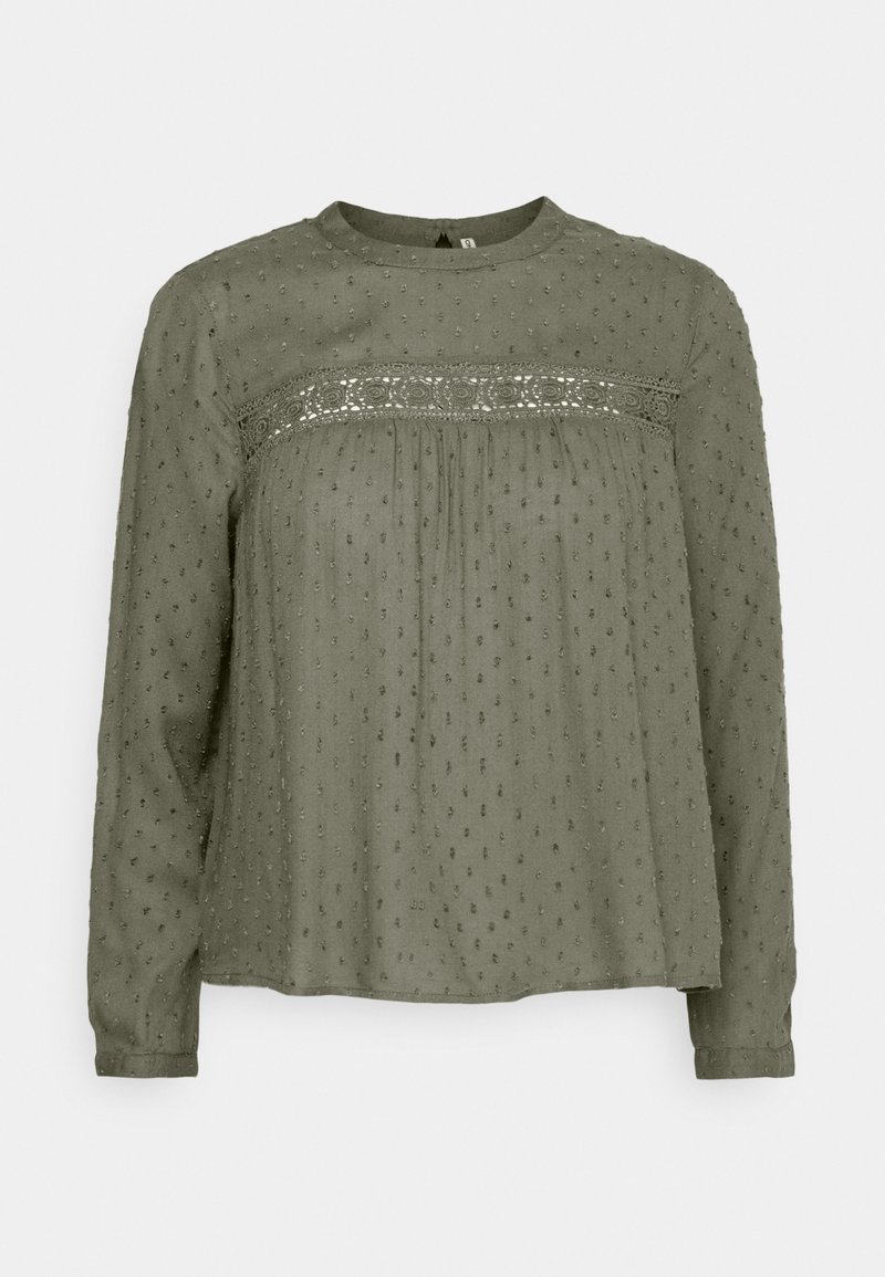 Blouse manches longues vert olive avec texture à points en relief et détail en dentelle horizontale sur la poitrine et le haut du dos.