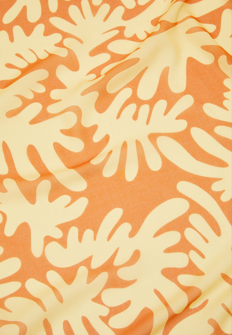 Cotton fabric featuring a repeating abstract pattern of orange and yellow organic shapes on a smooth, slightly textured surface.
