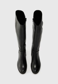 Térdmagasságú fekete bőrcsizmák sima textúrával, kerek orral és oldalsó cipzárral. Elegáns, minimalista dizájn, minták nélkül.