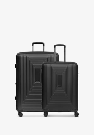 Due valigie rigide nere, con una superficie a coste, dotate di manici telescopici e ruote girevoli per un facile trasporto.