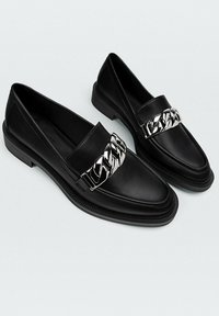 Sorte læder loafers med en sølvkædeaccent. Rund tå, lav stablet hæl og tekstureret sål for godt greb. Klassiske designelementer.