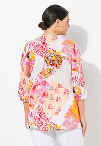 Camicia multicolore con audaci stampe di animali e geometriche. Realizzata in tessuto leggero con una vestibilità ampia e maniche arrotolate.