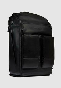 Mochila de cuero negro con diseño estructurado, que cuenta con múltiples compartimentos con cremallera y dos bolsillos delanteros para almacenamiento adicional.