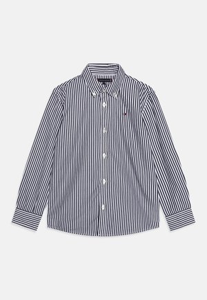 Langärmliges Hemd in Marine- und Weißstreifen, Baumwollmaterial, Button-Down-Kragen, mit dezentem Logodetail auf der Brust und kontrastierenden Manschetten.