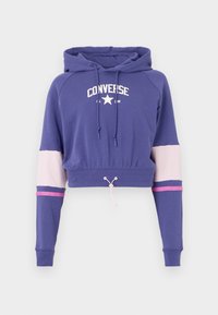 Sweatshirt roxo cortado com o logo branco "Converse All Star", capuz com cordão e riscas contrastantes em rosa claro e rosa escuro nas mangas.