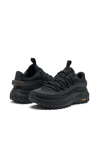 Musta ulkokäyttöön suunniteltu kengät, joissa on teksturoitu synteettinen päällinen, kestävä harmaa pohja, selkeä nauhoitusjärjestelmä ja Vibram-brändäys oranssilla korostuksella.