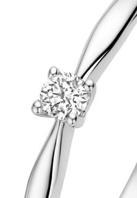 Zilveren ring met een ronde, fonkelende diamant in het midden, omringd door vier pootjes, met een gedraaide bandontwerp.