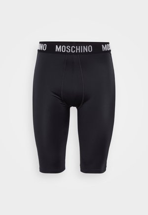 Bermudas pretas em tecido elástico com uma cintura elástica que apresenta o logo da Moschino em branco. Textura suave, design até ao joelho e forma ajustada.