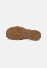 Semelle d'une chaussure marron avec des motifs de bande de roulement semblables à des empreintes digitales et le nom de la marque Gabor embossé près du centre.